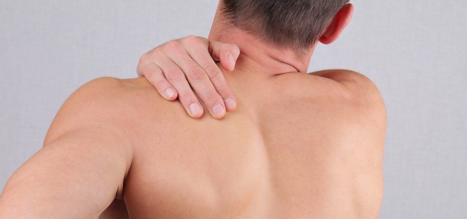 Man with neck and back pain. Man rubbing his painful back close up. Pain relief concept